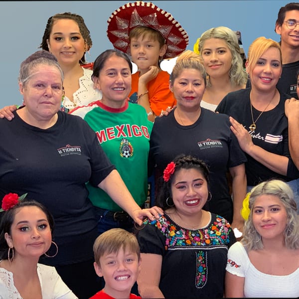 A large group of La Tiendita Mexican Restaurant staff and family members smiling together.